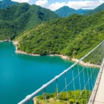 Langkawi Sky Bridge dengan latar belakang gunung Machinchang yang hijau dan langit biru cerah.